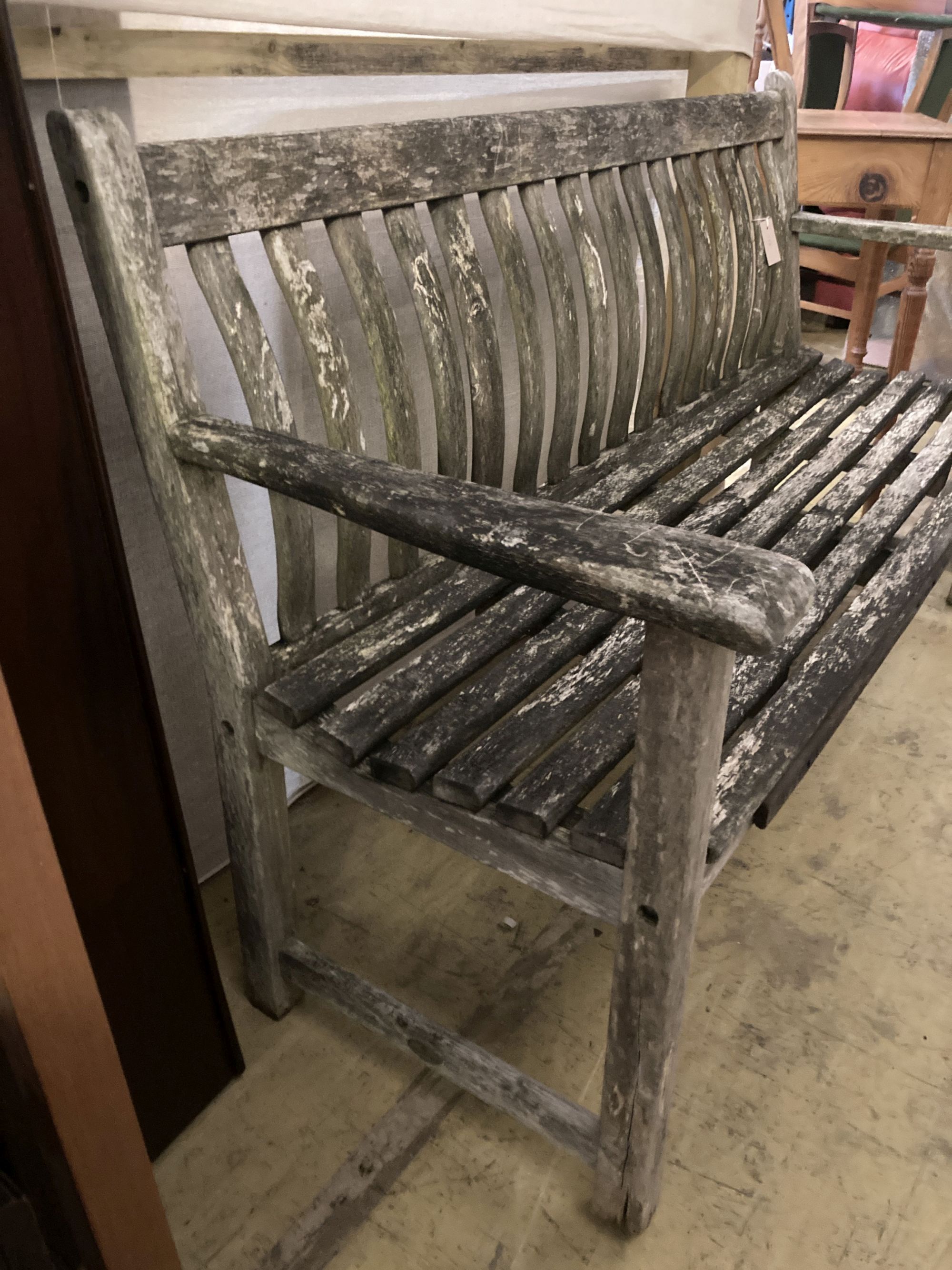 A weathered teak garden bench, length 150cm, depth 55cm, height 86cm